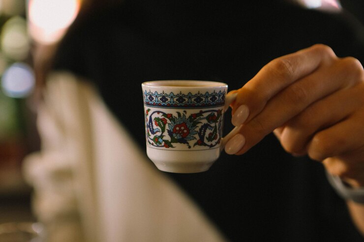 امرأ تحمل كوب قهوة عربي
